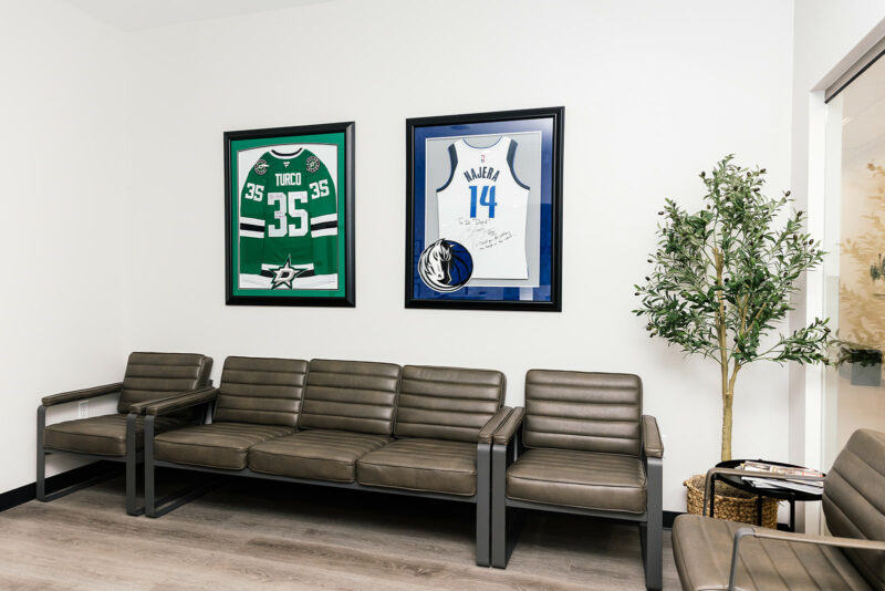 Waiting room wall with framed, signed Dallas Stars and Dallas Mavericks jerseys
